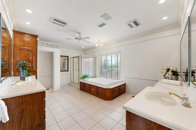 a spacious bathroom with a double vanity sink a large mirror and a bathtub
