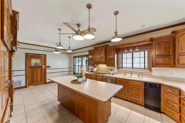 a large kitchen with kitchen island a stove a sink a dining table and chairs with wooden floor