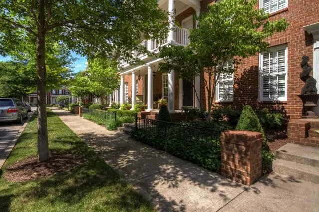 a view of a patio with table and chairs and potted plants and large trees