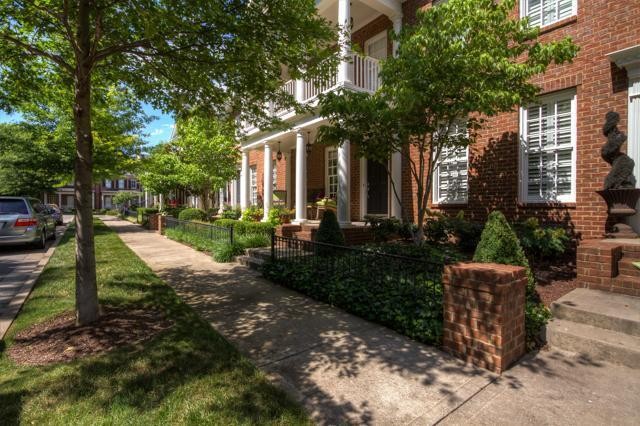 a view of a patio with table and chairs and potted plants and large trees