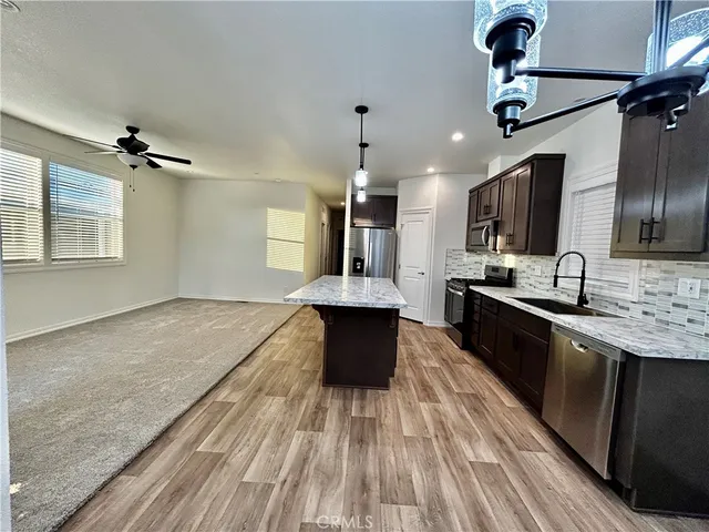 a large kitchen with kitchen island a stove a sink and a refrigerator