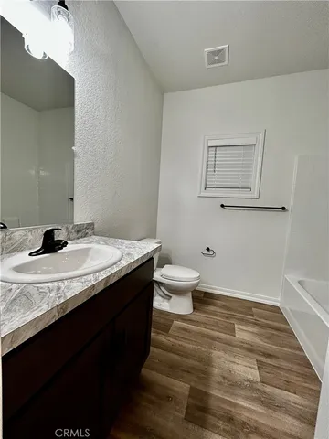 a bathroom with a granite countertop sink a toilet and a mirror