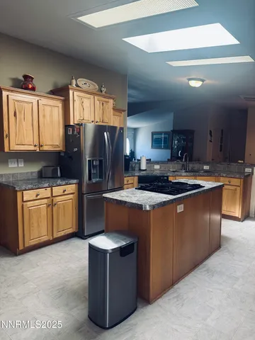 a kitchen with stainless steel appliances granite countertop a stove a sink dishwasher a refrigerator and a microwave