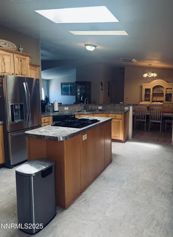 a kitchen with stainless steel appliances granite countertop a stove top oven a refrigerator a sink and dishwasher