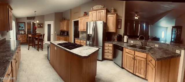 a kitchen with stainless steel appliances granite countertop a sink stove and cabinets