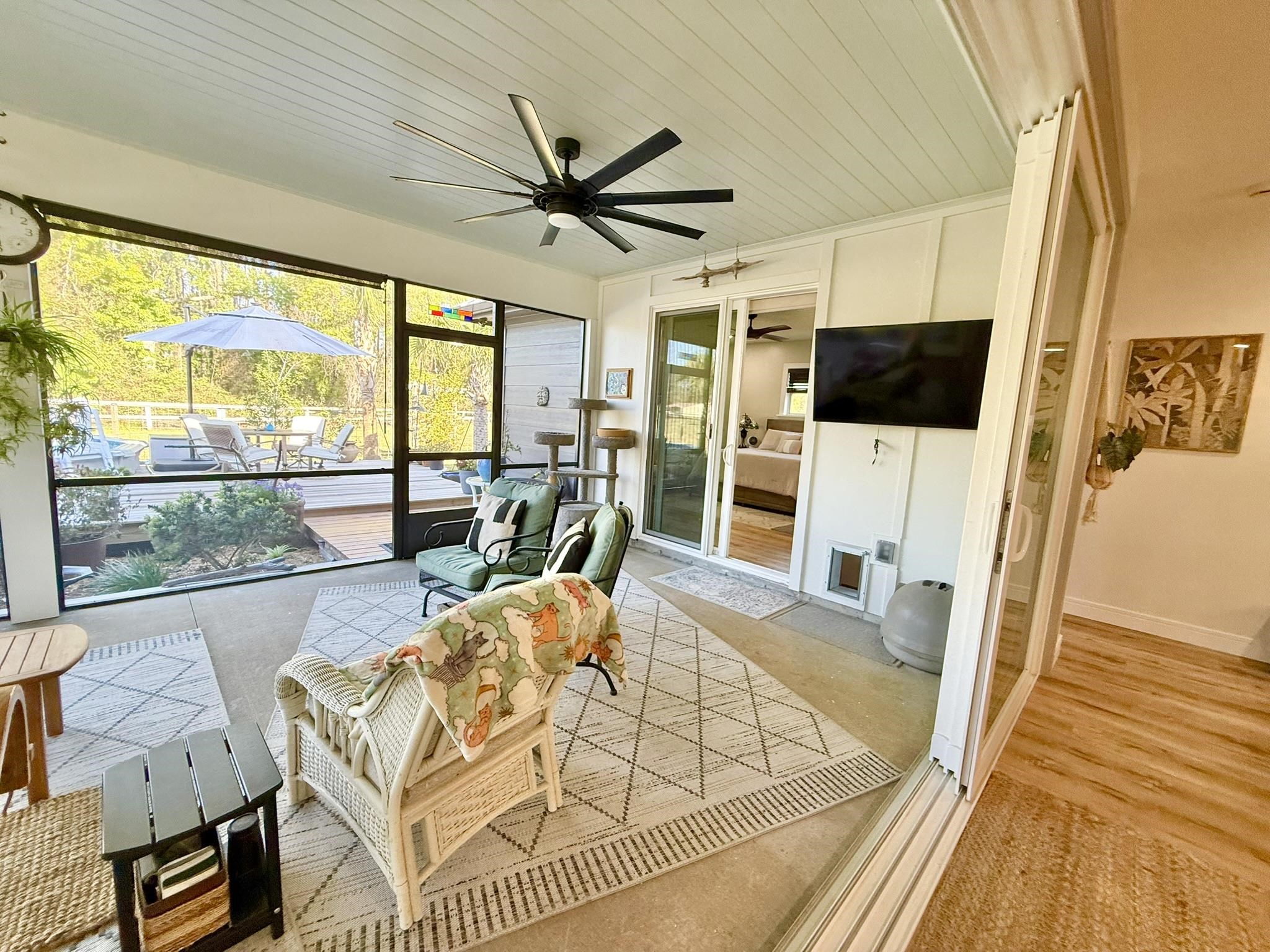146 Maple Tree Lane Elkton, FL 32033 - Photo 15 of 75 a living room with furniture a flat screen tv and a floor to ceiling window