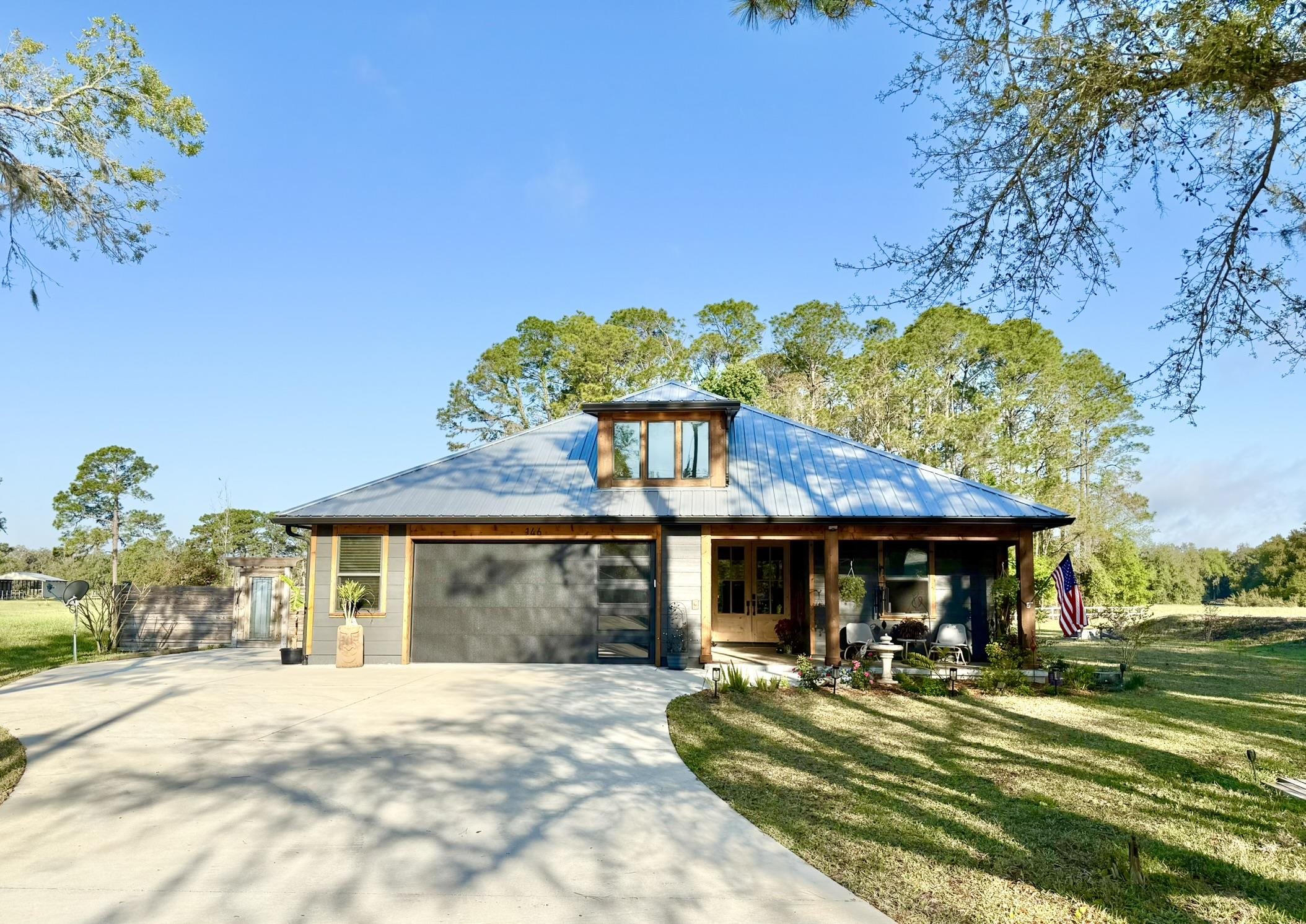 146 Maple Tree Lane Elkton, FL 32033 - Photo 2 of 75 a front view of a house with a garden