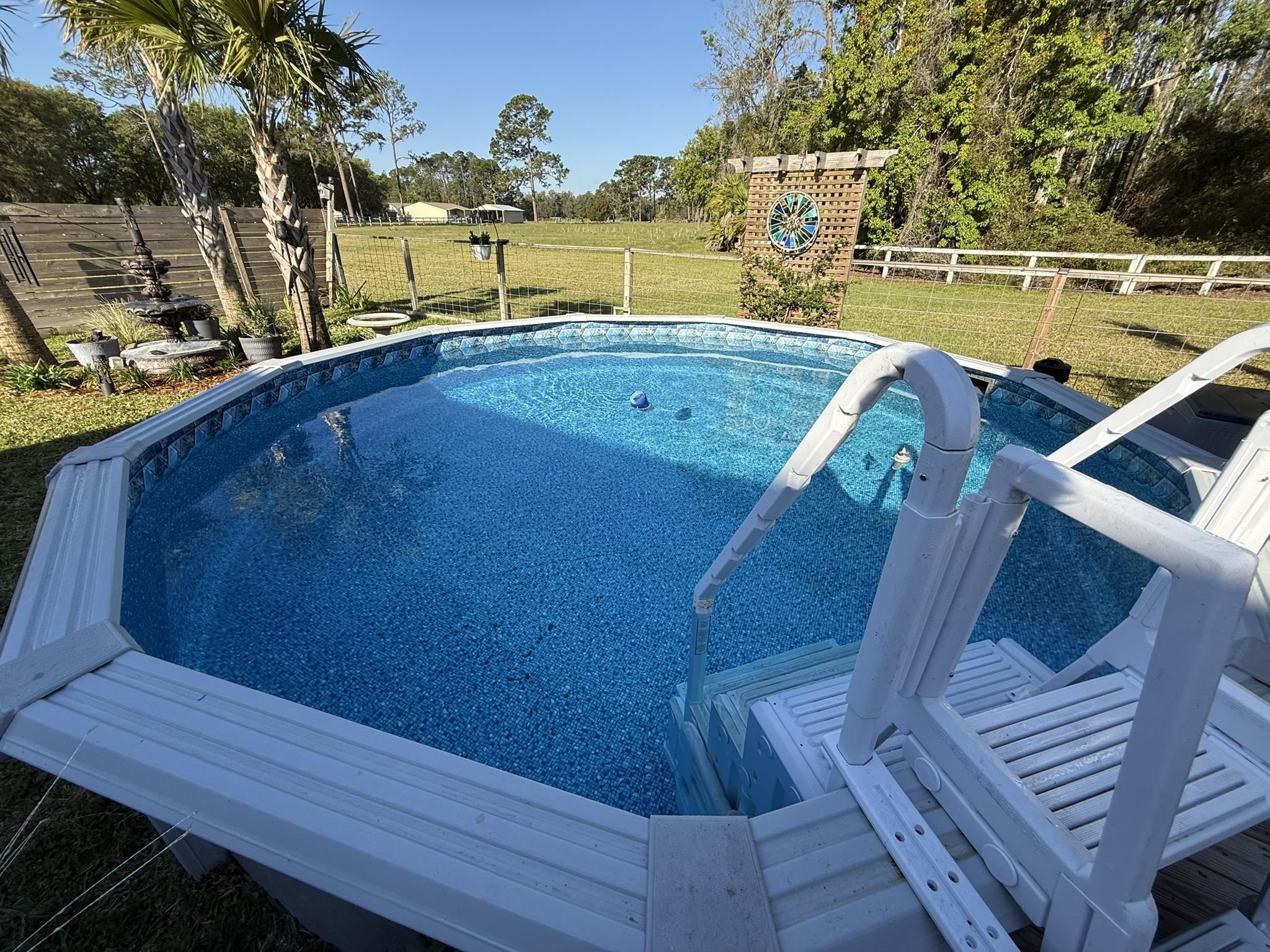146 Maple Tree Lane Elkton, FL 32033 - Photo 22 of 75 a view of a swimming pool with a lounge chairs