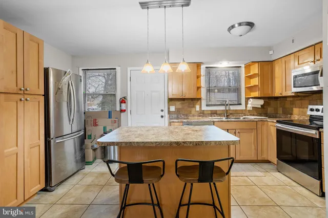 a kitchen with stainless steel appliances granite countertop a stove refrigerator sink and cabinets