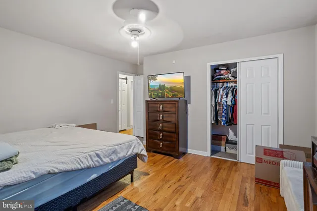 a bedroom with a bed and a flat tv screen on dresser