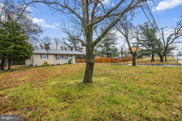 a view of house with yard and trees