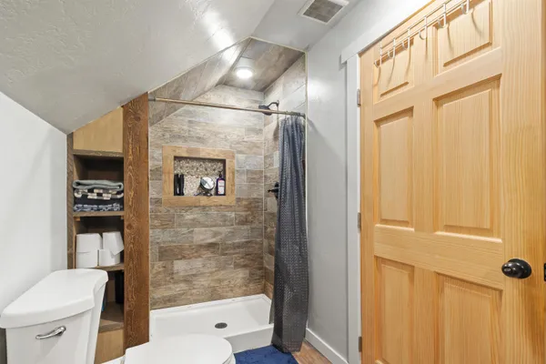 a bathroom with a toilet and a shower