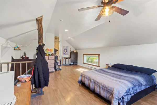 a bedroom with bed and wooden floor