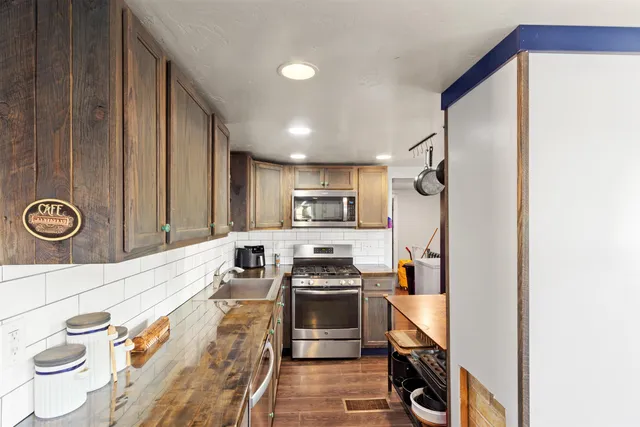 a kitchen with stainless steel appliances granite countertop a stove and a refrigerator