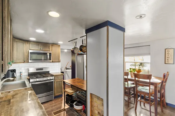 a kitchen with a refrigerator and a stove top oven