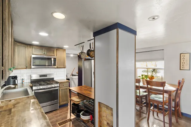 a kitchen with a refrigerator and a stove top oven