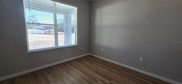 a view of an empty room with closet and a window