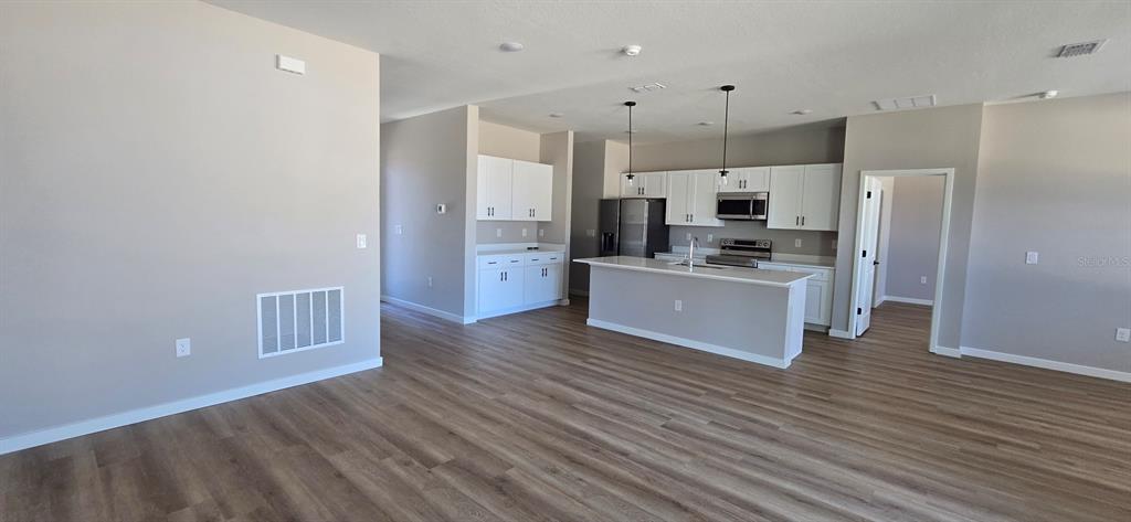 9975 Southwest 39th Terrace Ocala, FL 34476 - Photo 2 of 13 a kitchen with stainless steel appliances a refrigerator and wooden floor