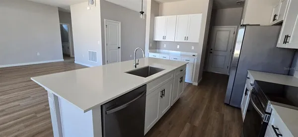 a kitchen with stainless steel appliances granite countertop a sink a refrigerator and a stove