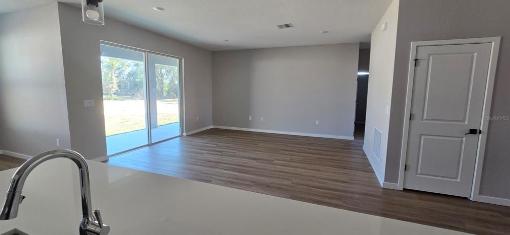 9975 Southwest 39th Terrace Ocala, FL 34476 - Photo 5 of 13 an empty room with wooden floor and window