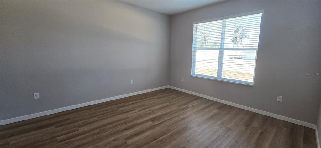 9975 Southwest 39th Terrace Ocala, FL 34476 - Photo 6 of 13 a view of an empty room with wooden floor and a window