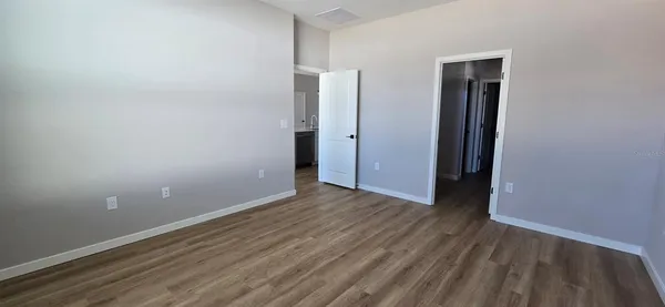 a view of an empty room with closet and a window