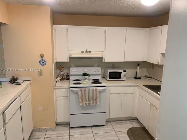 Hialeah Hialeah, FL 33012 - Photo 13 of 18 a kitchen with granite countertop white cabinets and white appliances