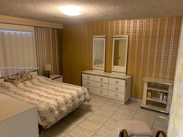 Hialeah Hialeah, FL 33012 - Photo 14 of 18 a bedroom with a bed and cabinets