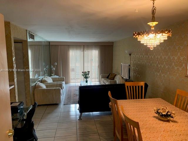 Hialeah Hialeah, FL 33012 - Photo 9 of 18 a living room with a table chairs and a chandelier