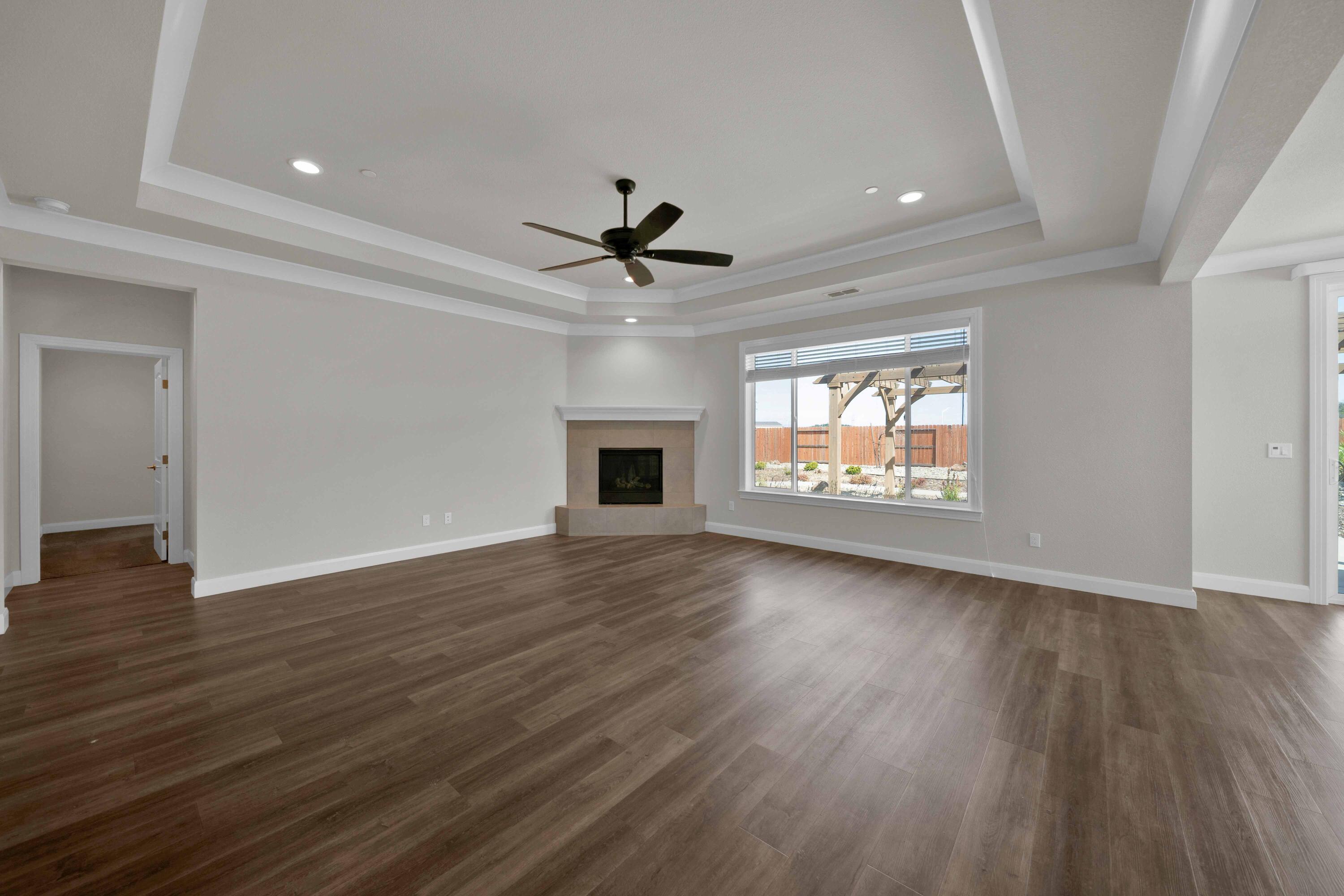 4771 Lower Springs Road Redding, CA 96001 - Photo 13 of 34 an empty room with wooden floor a ceiling fan and windows