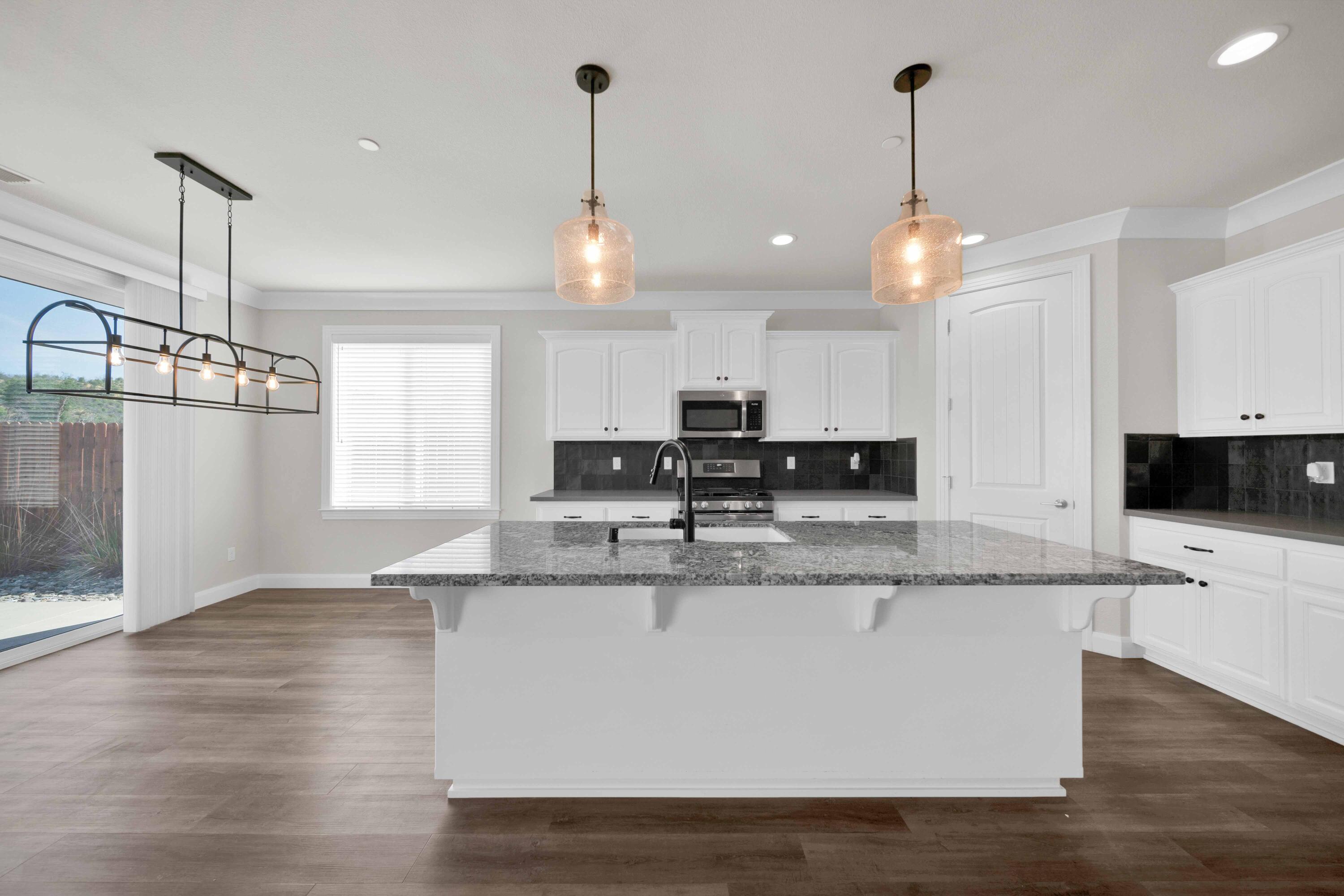 4771 Lower Springs Road Redding, CA 96001 - Photo 4 of 34 a large kitchen with stainless steel appliances granite countertop a sink a stove and a wooden floor