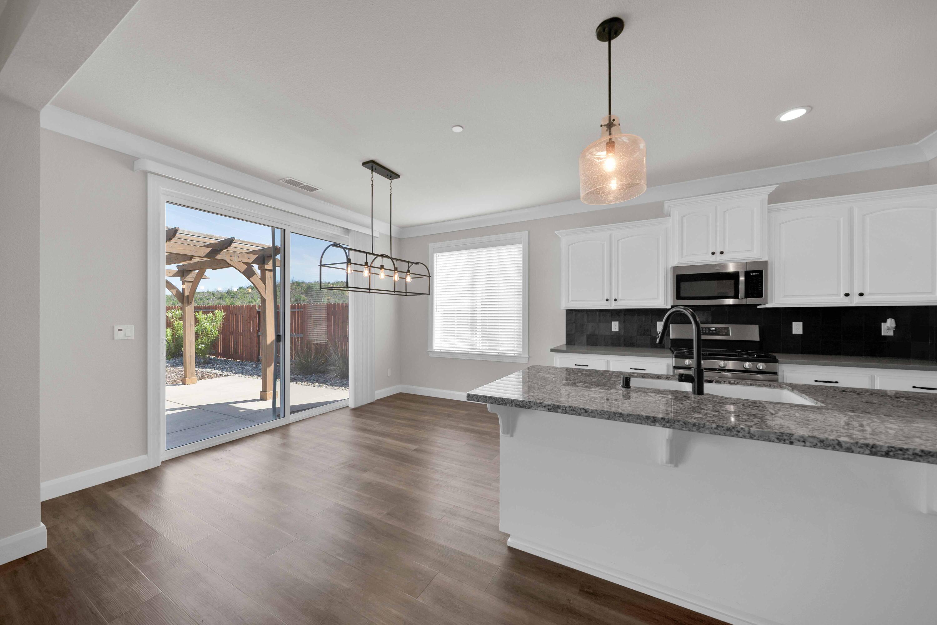 4771 Lower Springs Road Redding, CA 96001 - Photo 6 of 34 a view of a kitchen with a stove wooden cabinets and a chandelier