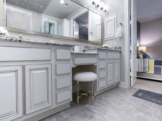 a room with stainless steel appliances kitchen island granite countertop a sink a stove a refrigerator and cabinets