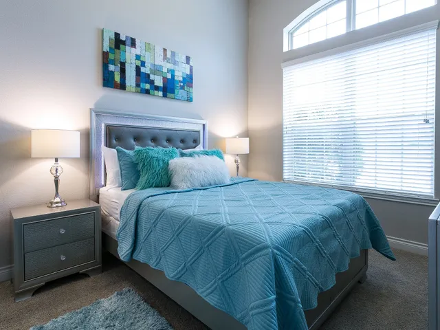 a bedroom with a bed and a night stand