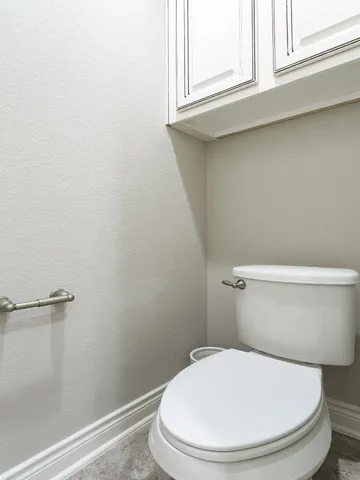 a white toilet sitting next to a window
