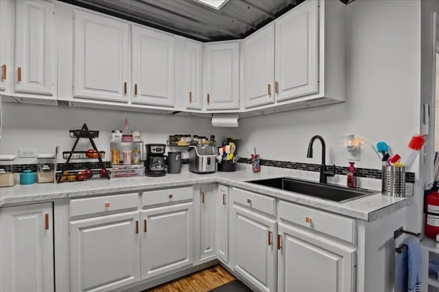a kitchen with stainless steel appliances cabinets and a wooden floor