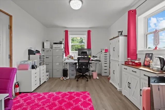 a view of wooden house with a small yard and large trees