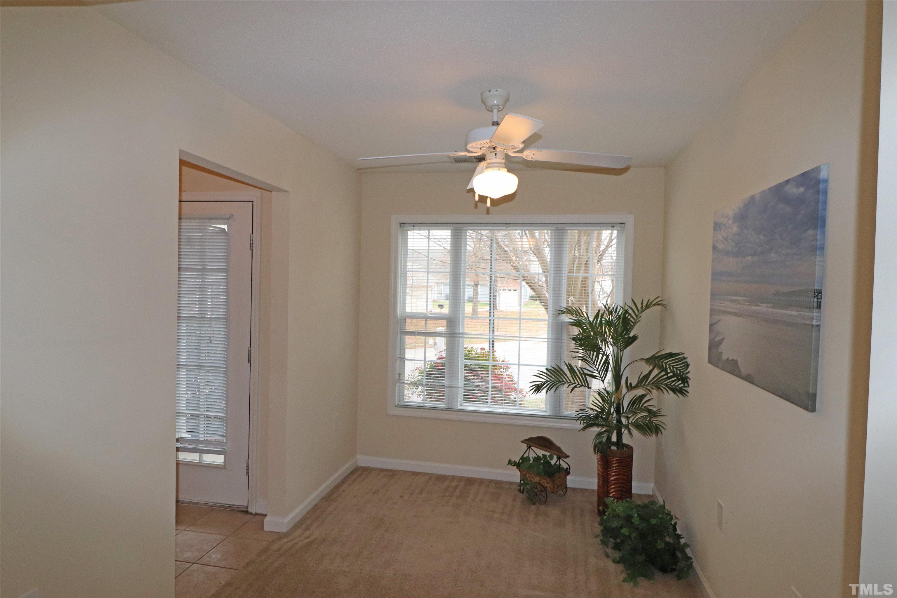 11301 Clubhaven Place, Unit 102 Raleigh, NC 27617 - Photo 11 of 53 a view of a livingroom with a potted plant a ceiling fan and a window