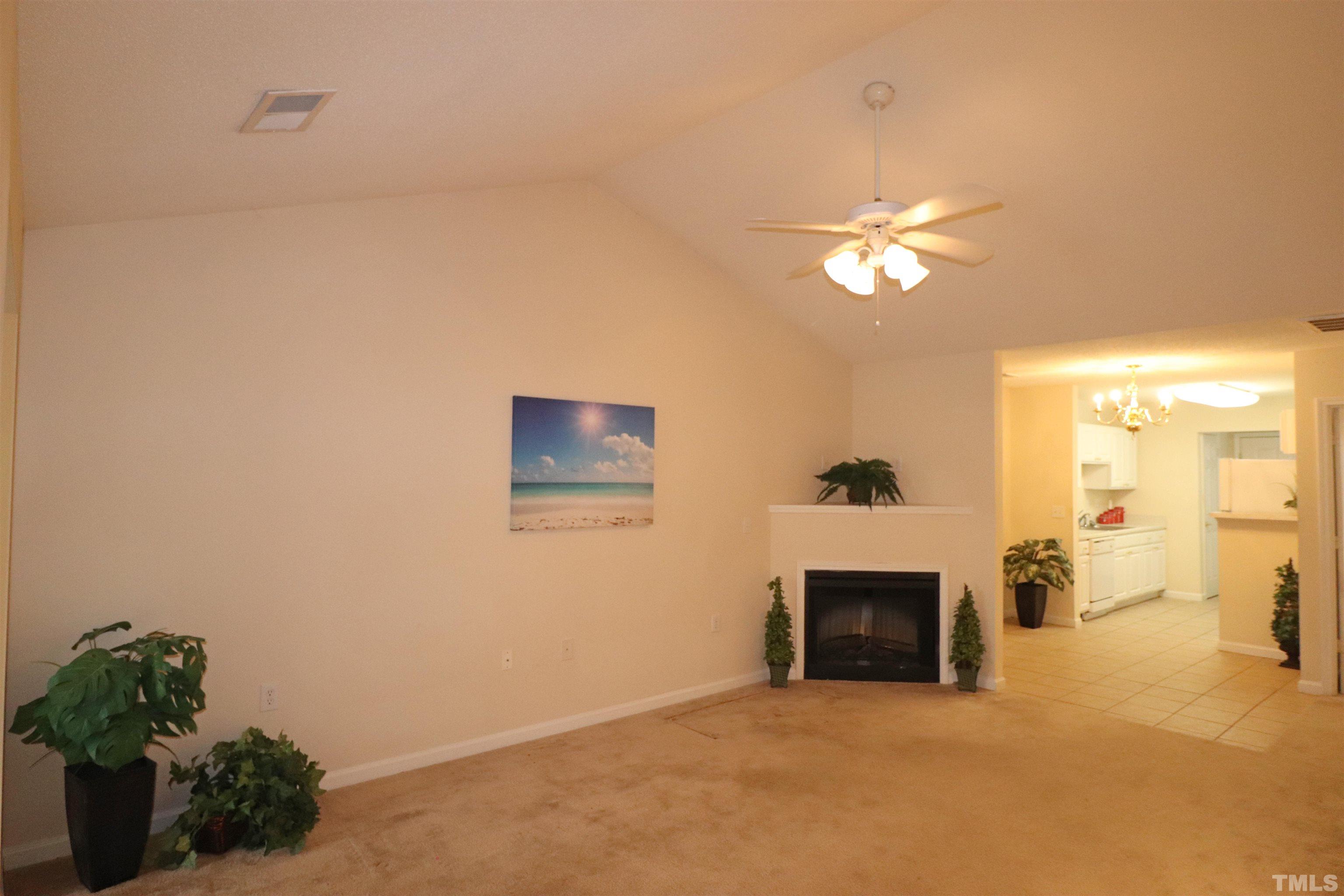 11301 Clubhaven Place, Unit 102 Raleigh, NC 27617 - Photo 16 of 53 a view of a livingroom with a fireplace and a chandelier fan