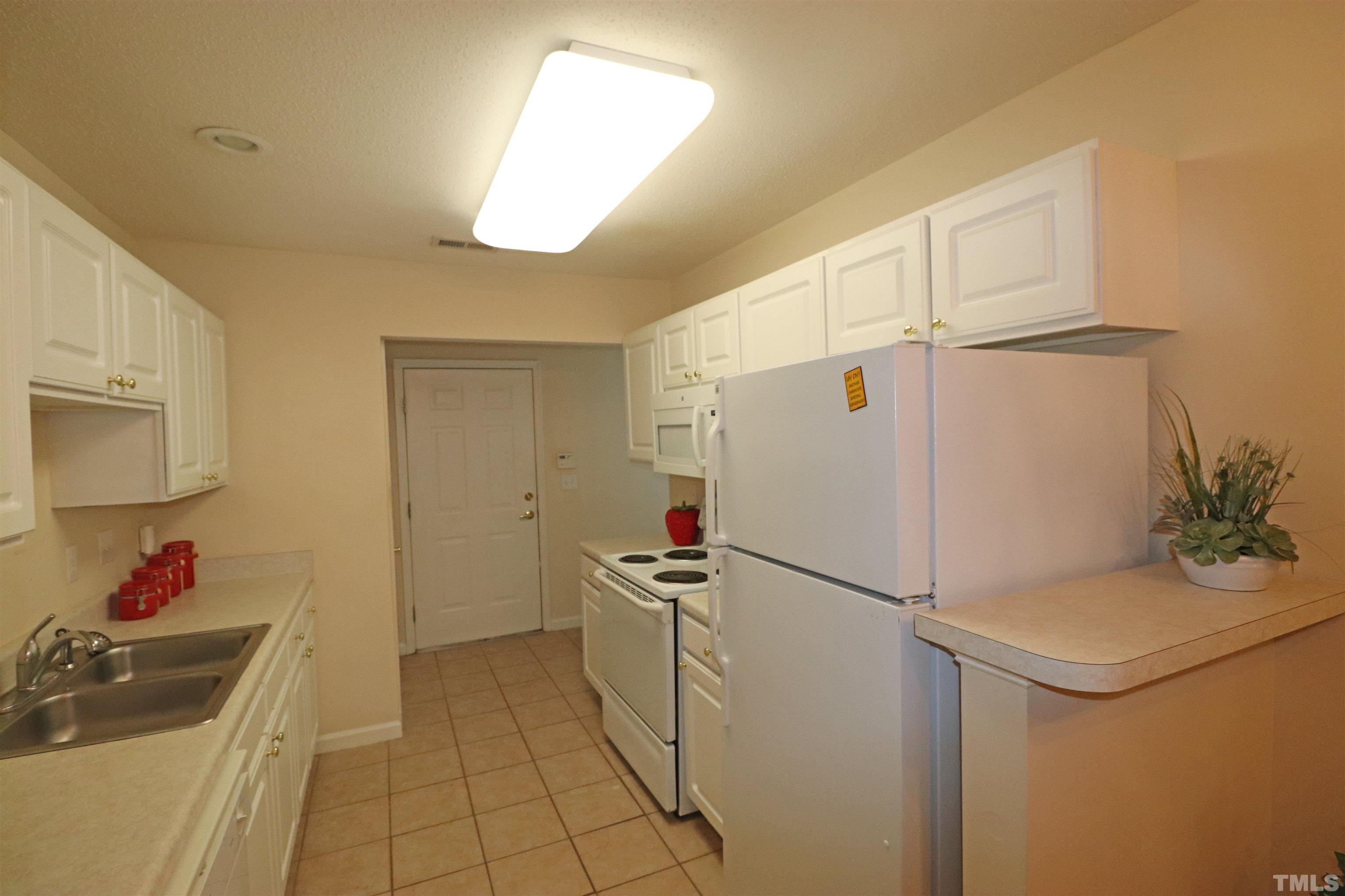 11301 Clubhaven Place, Unit 102 Raleigh, NC 27617 - Photo 26 of 53 a kitchen with stainless steel appliances a refrigerator sink and cabinets