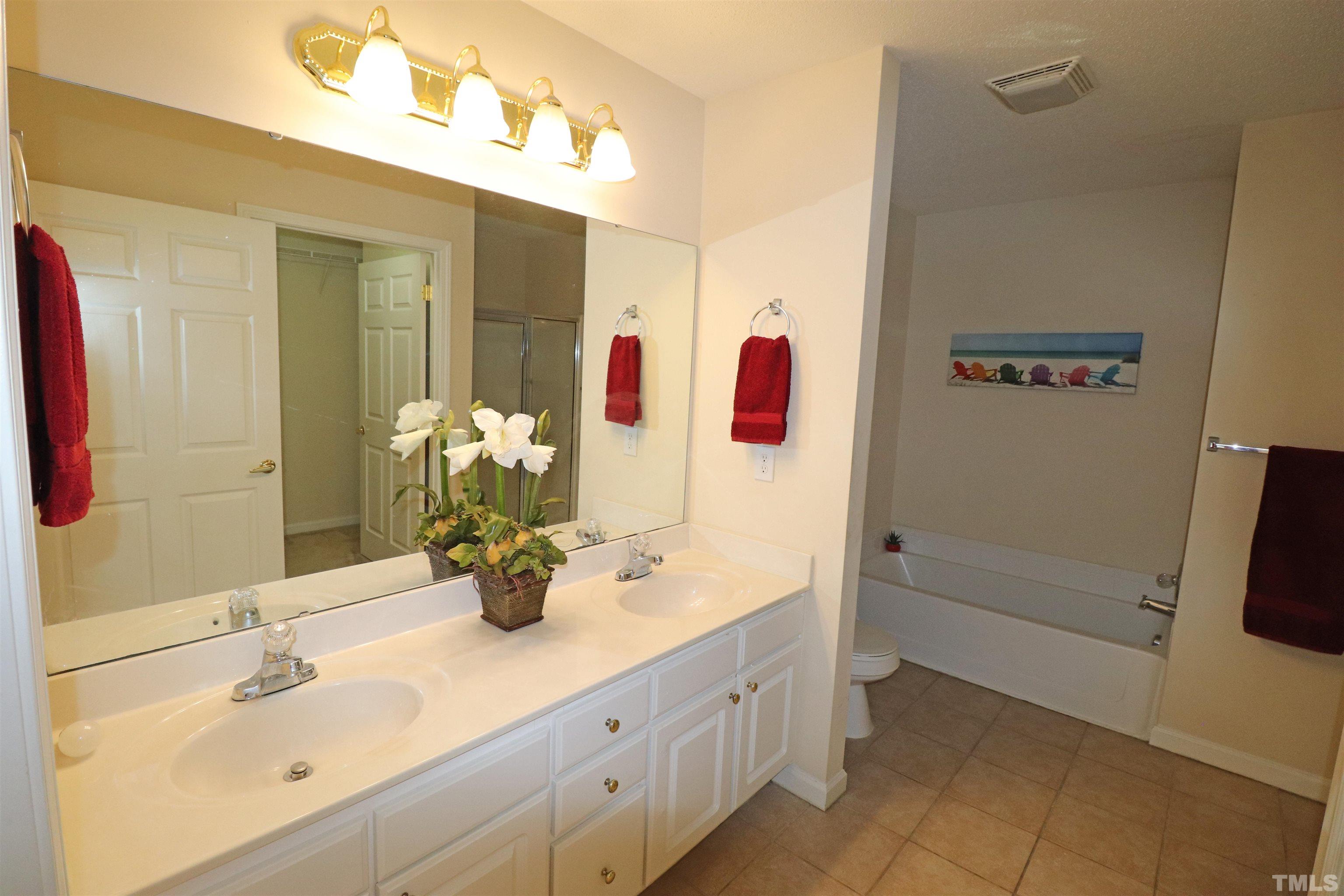 11301 Clubhaven Place, Unit 102 Raleigh, NC 27617 - Photo 38 of 53 a bathroom with a tub sink and mirror