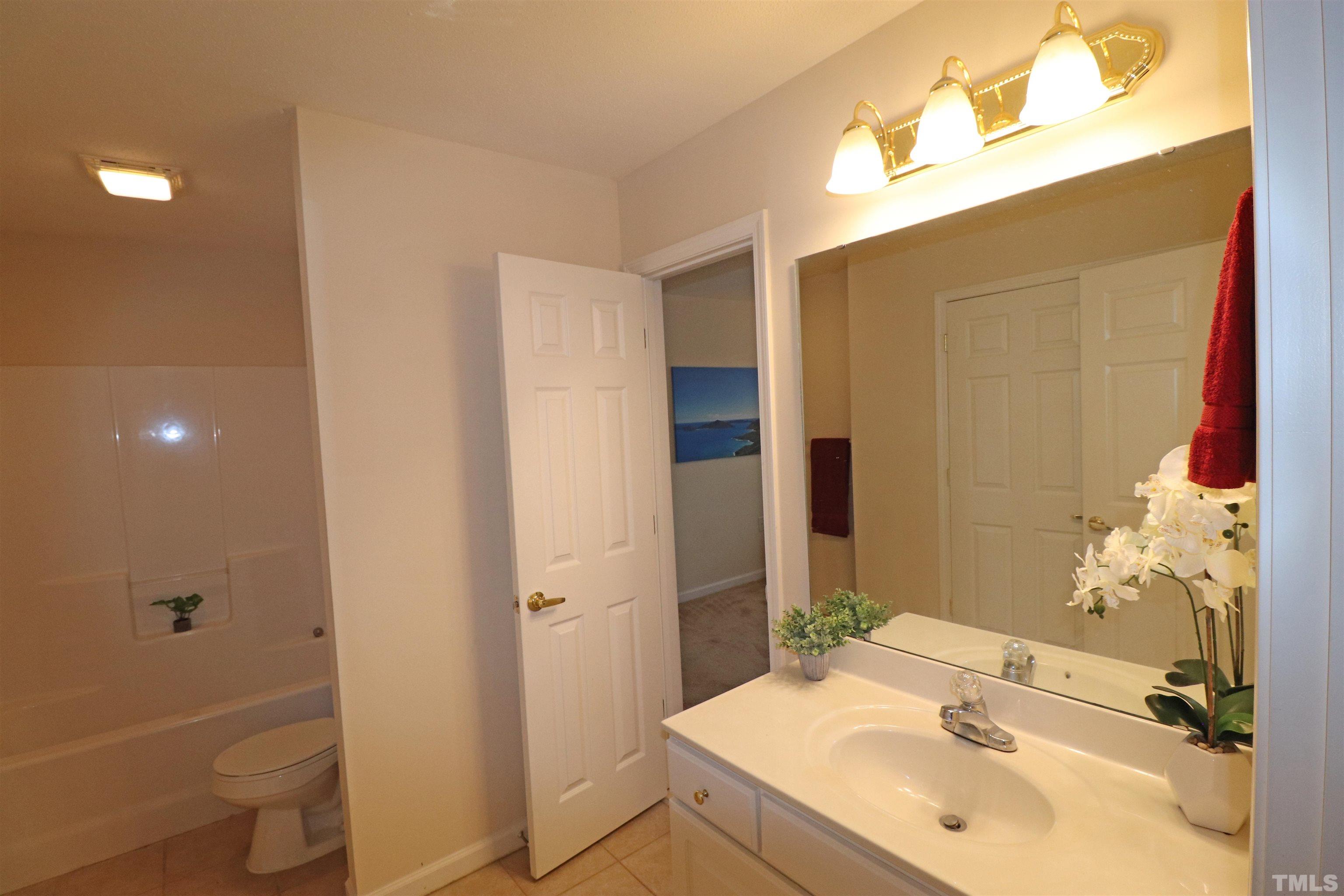 11301 Clubhaven Place, Unit 102 Raleigh, NC 27617 - Photo 44 of 53 a bathroom with a sink and mirror with toilet