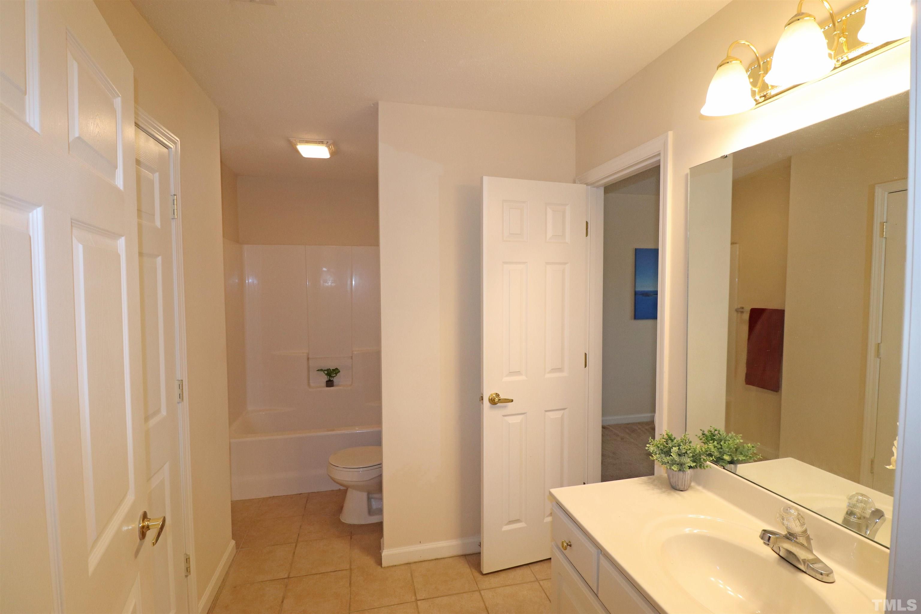 11301 Clubhaven Place, Unit 102 Raleigh, NC 27617 - Photo 45 of 53 a bathroom with a granite countertop sink a toilet and shower