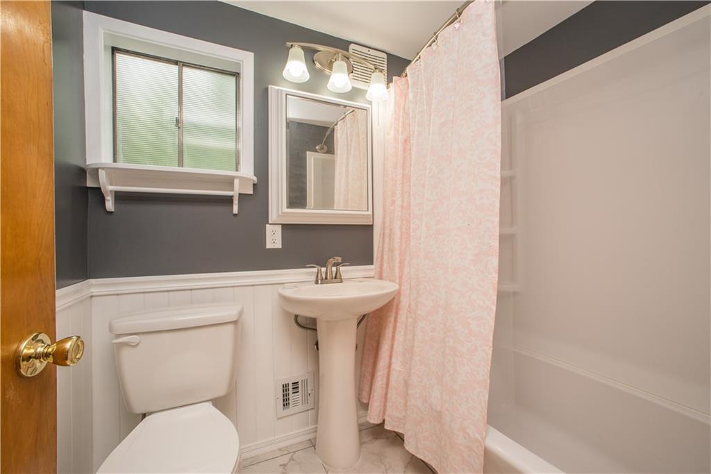 3816 West Run Road Homestead, PA 15120 - Photo 14 of 21 The second full bath has been updated with modern fixtures, pedestal sink, and combination tub, shower and surround. Wainscoting and chair rail trim add decorative flair in this room.