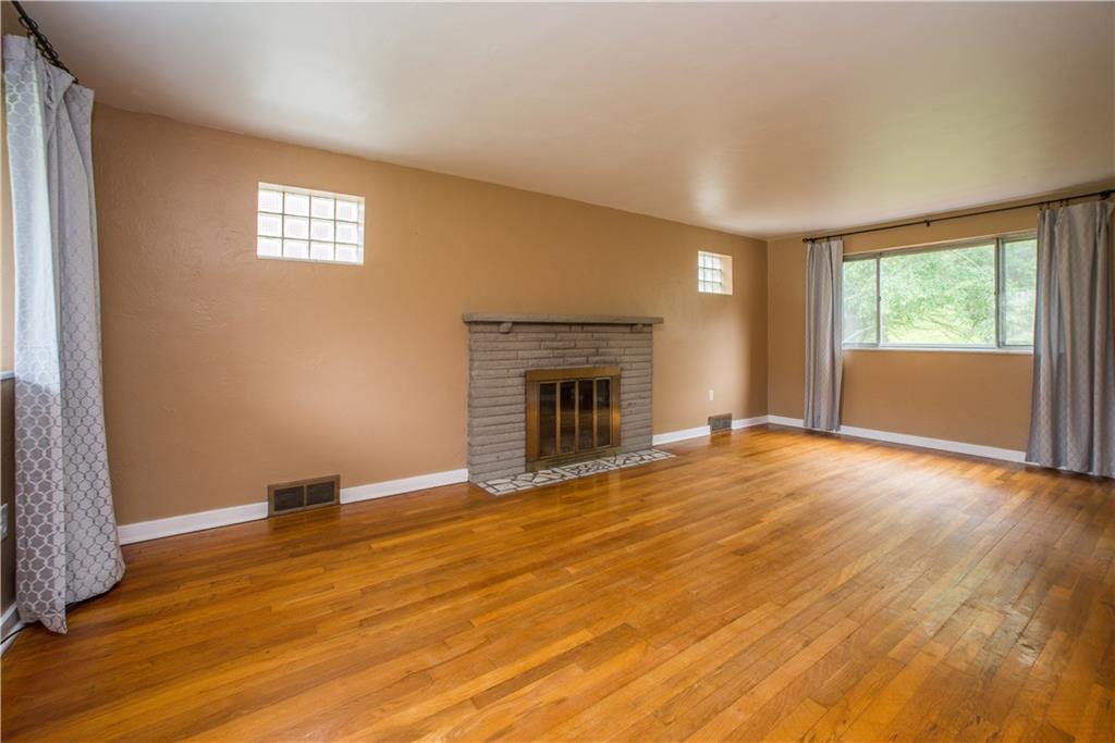 3816 West Run Road Homestead, PA 15120 - Photo 5 of 21 This is the living room as seen from the front entry. The stone-surround, log-burning fireplace is flanked by glass block windows facing the side of the home. Another large window faces the front of the home.