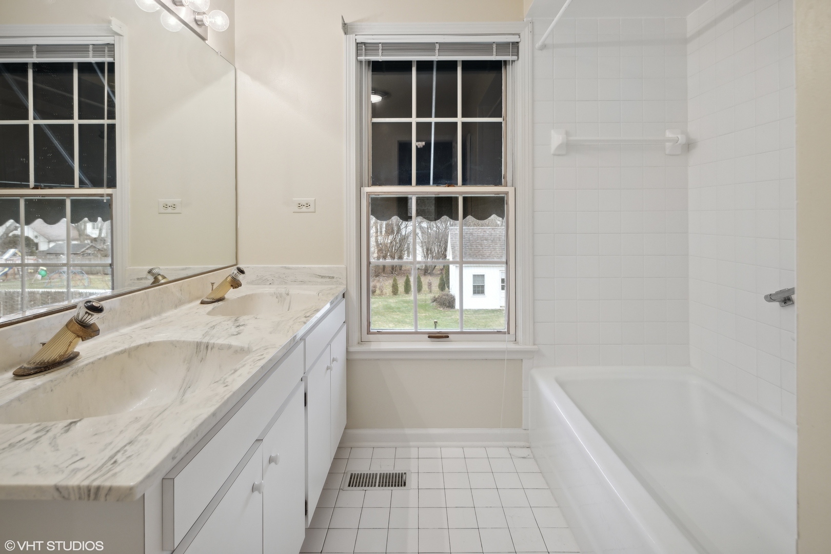 1050 South Ridge Road Lake Forest, IL 60045 - Photo 34 of 40 a bathroom with a granite countertop sink a mirror and a bathtub