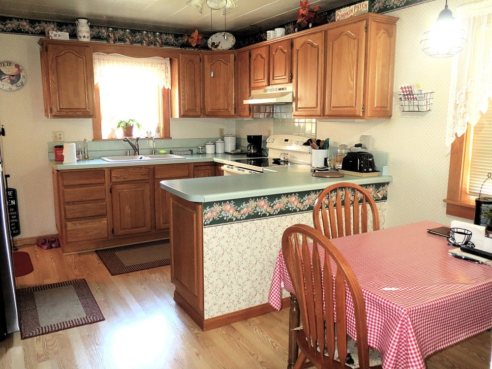 1027 Bluff Road Dixon, IL 61021 - Photo 7 of 48 a kitchen with stainless steel appliances granite countertop a sink dishwasher a stove a microwave oven and a dining table with wooden floor