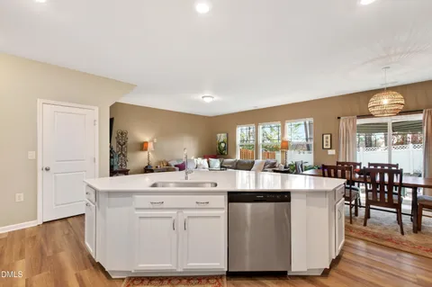 a room with kitchen island a white counter top space a sink and appliances