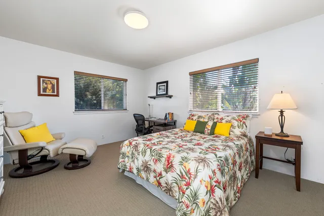 a bed room with two bed and a chair