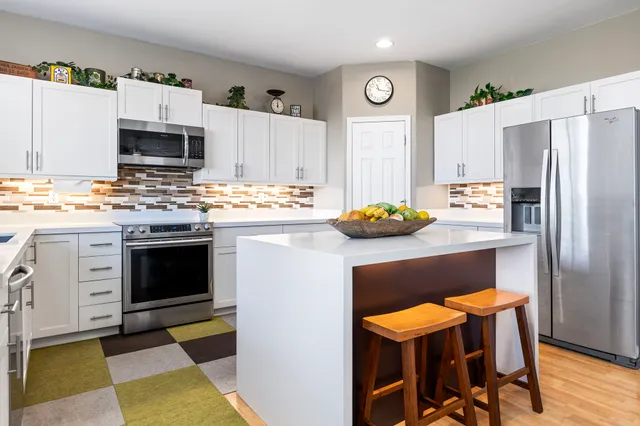 a kitchen with stainless steel appliances a stove a sink and a refrigerator